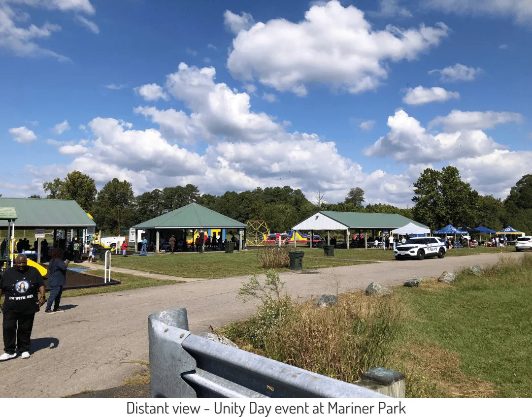 Distant view of the Unity Day event at Mariner Park; several pavilions and play equipment are visible.