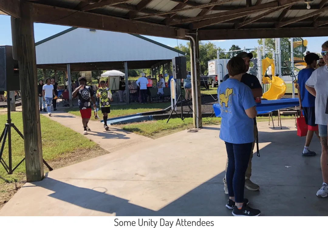 A view under one pavilion and into another with several groups of people in attendance at Unity Day 2024.