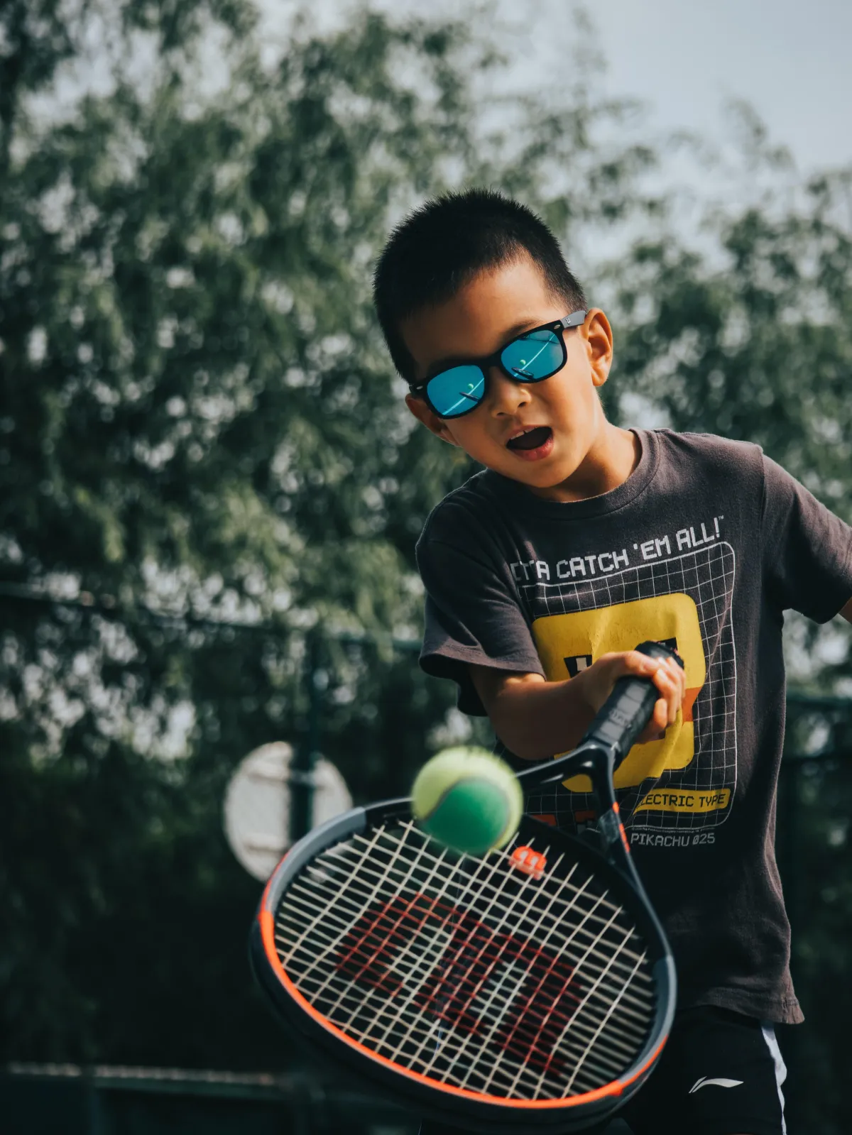 kid hitting a tennis ball.