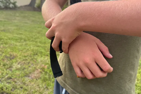 Son putting wrist guard on before bowhunting trip