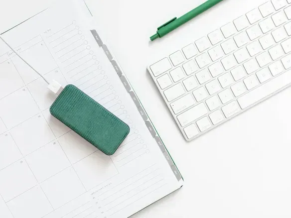 white keyboard and notebook with green accents