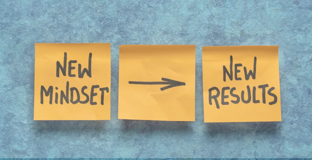 Three sticky notes on a blue background reading “New Mindset → New Results.”