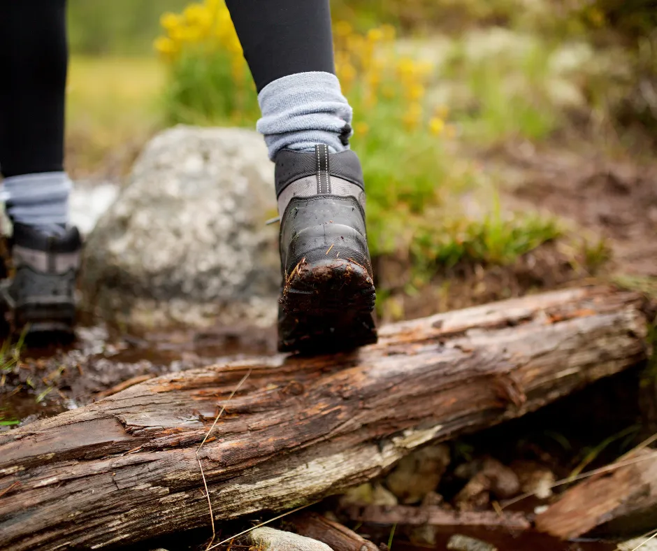 woman walking over log