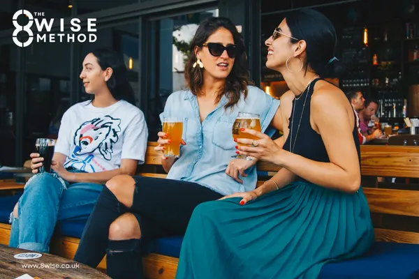 Group of woman sat outside at a bar enjoying a craft beer