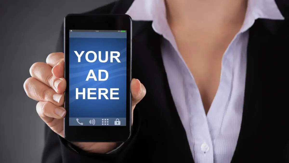 Women holding a cell phone that says "your ad here"