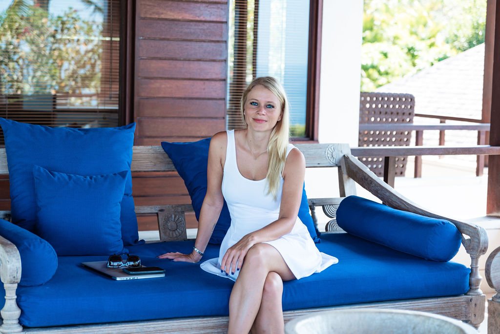 Woman sitting on a blue couch with a laptop while planning her day