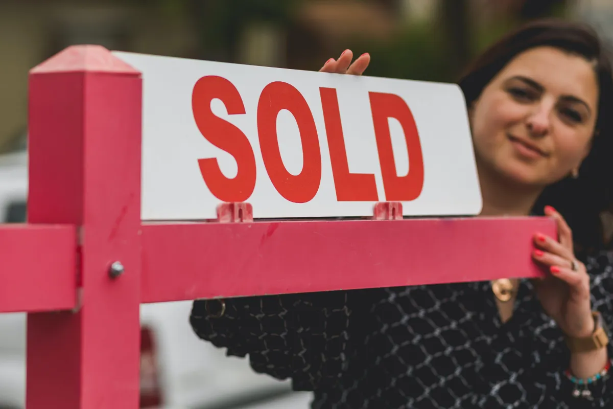 Realtor with sold sign on yard