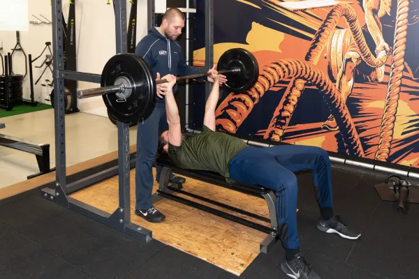 Personal trainer helpt een klant met krachttraining in een rustige gymomgeving bij Personal Training in The Unit in Heerenveen.