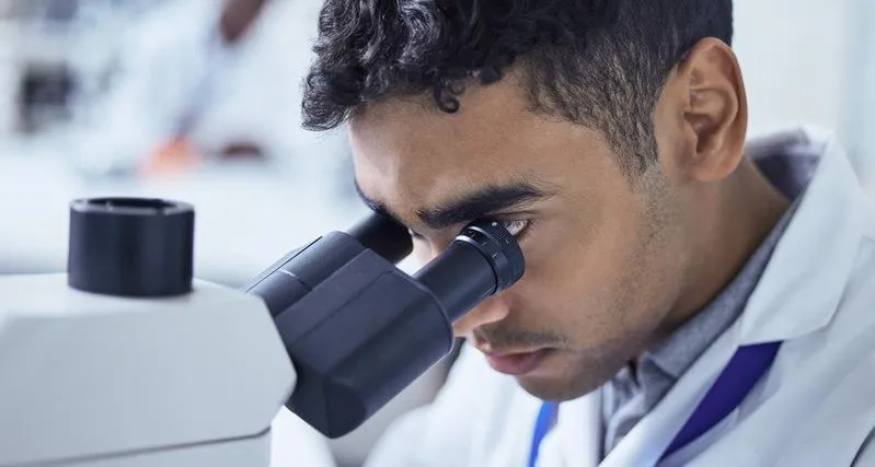 specialist focuses intently while looking through the microscope