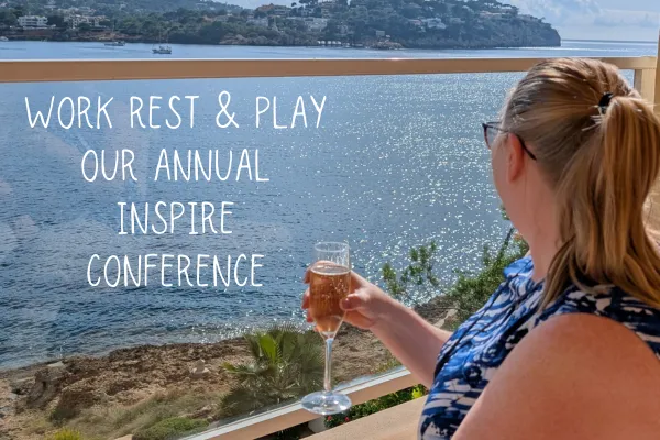 Woman with a glass of champagne looking out over beautiful blue seas