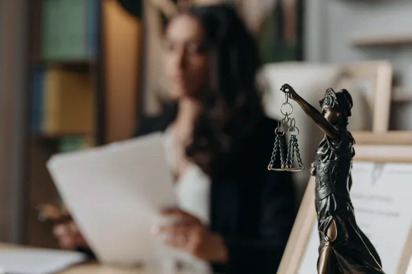 Notary with balance symbol and client reviewing a document.