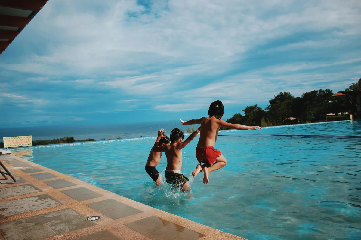 3 boys jumping in pool