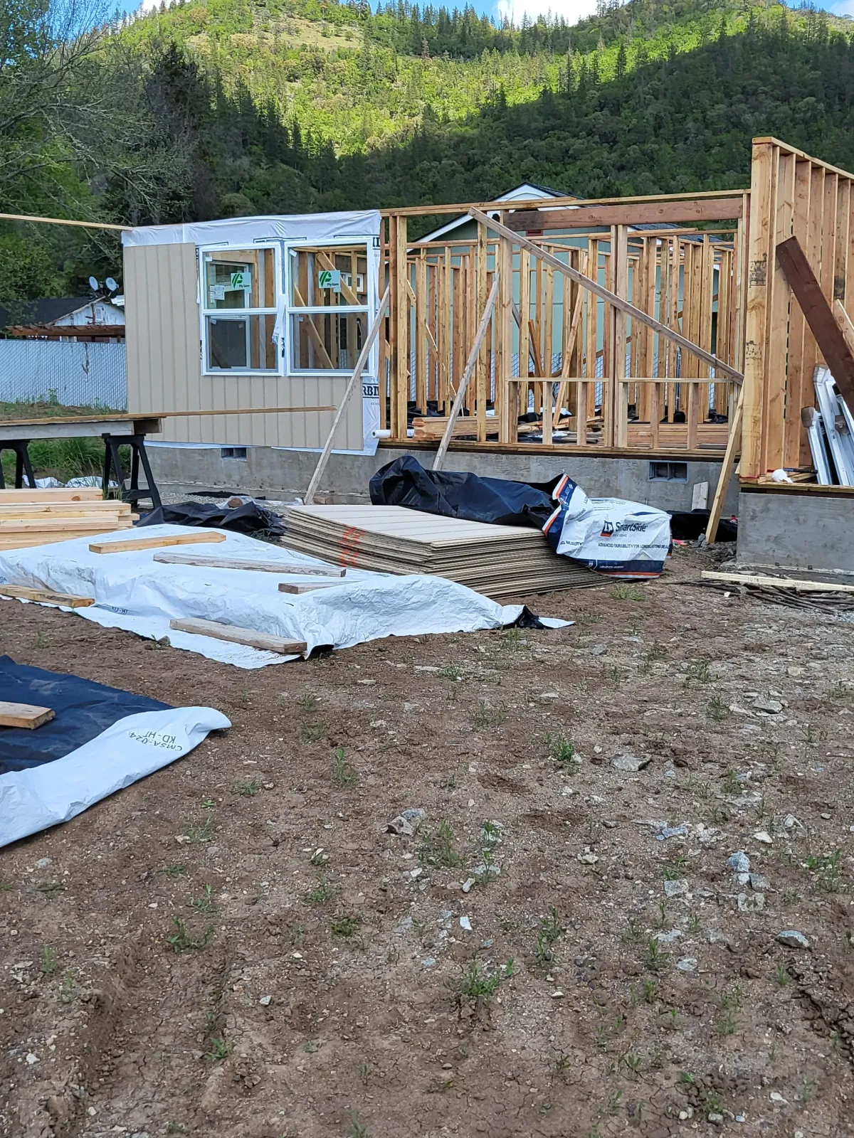Wood framing and foundation prep with protective tarps in Oregon residential build by Parker Built Construction