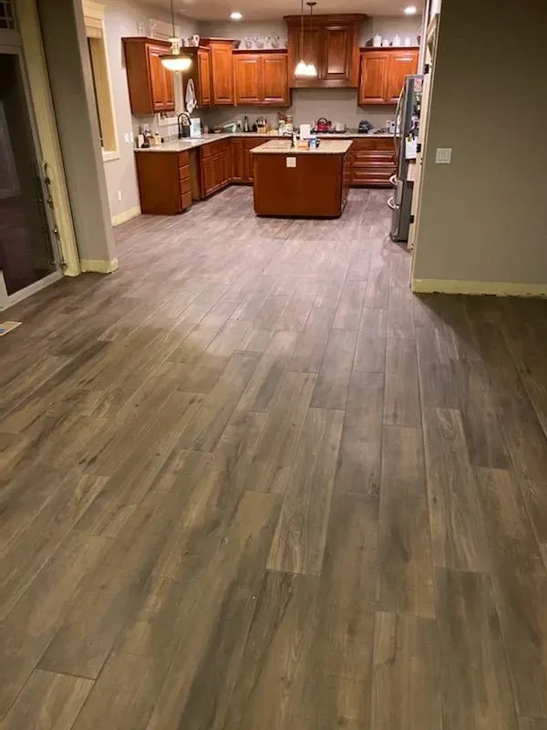 Freshly installed hardwood-style flooring in an open kitchen space by Parker Built Construction, Oregon