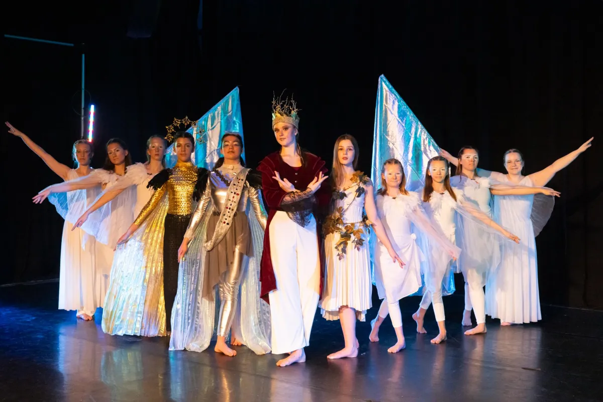 dancers and aerialists portraying God, Adam, Eve, and other biblical characters from the creation story pose for a photo.