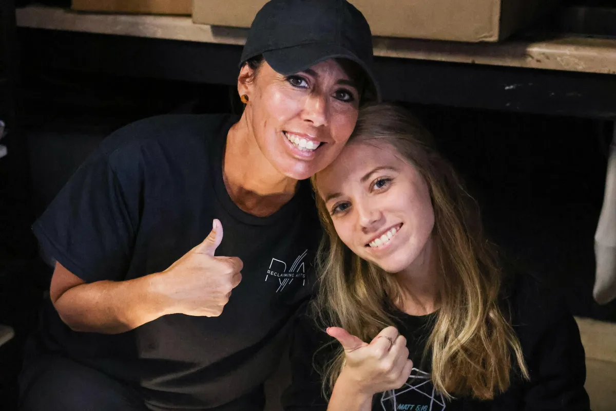 A mother and daughter give the camera a thumbs up.