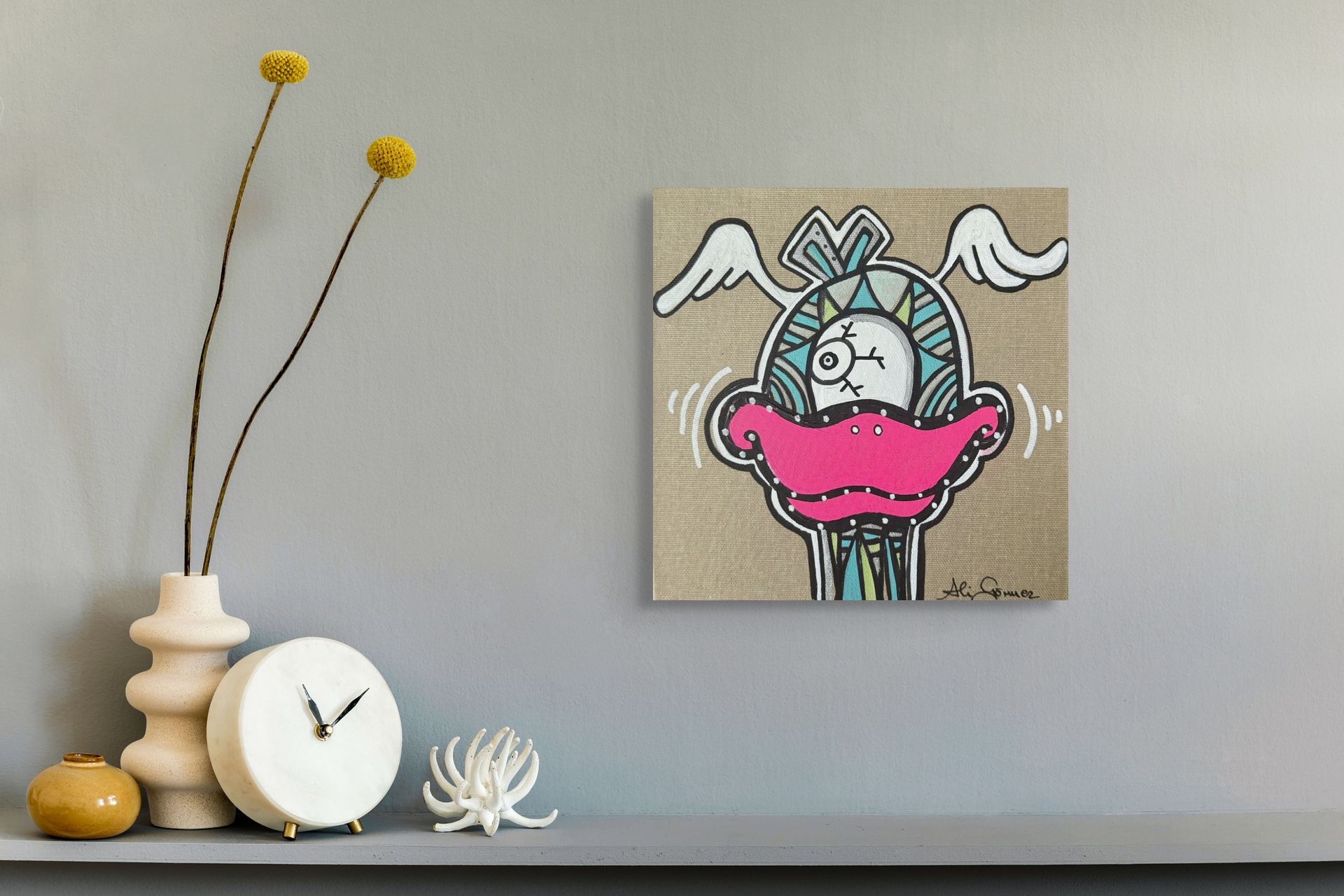 „‘Focky 21’ von Ali Görmez: Pop-Art-Ente mit neonpinken Schnabel, Einauge und weißen Flügeln auf naturfarbener Leinwand, stilvoll inszeniert über grauem Board mit Vase und Uhr.“