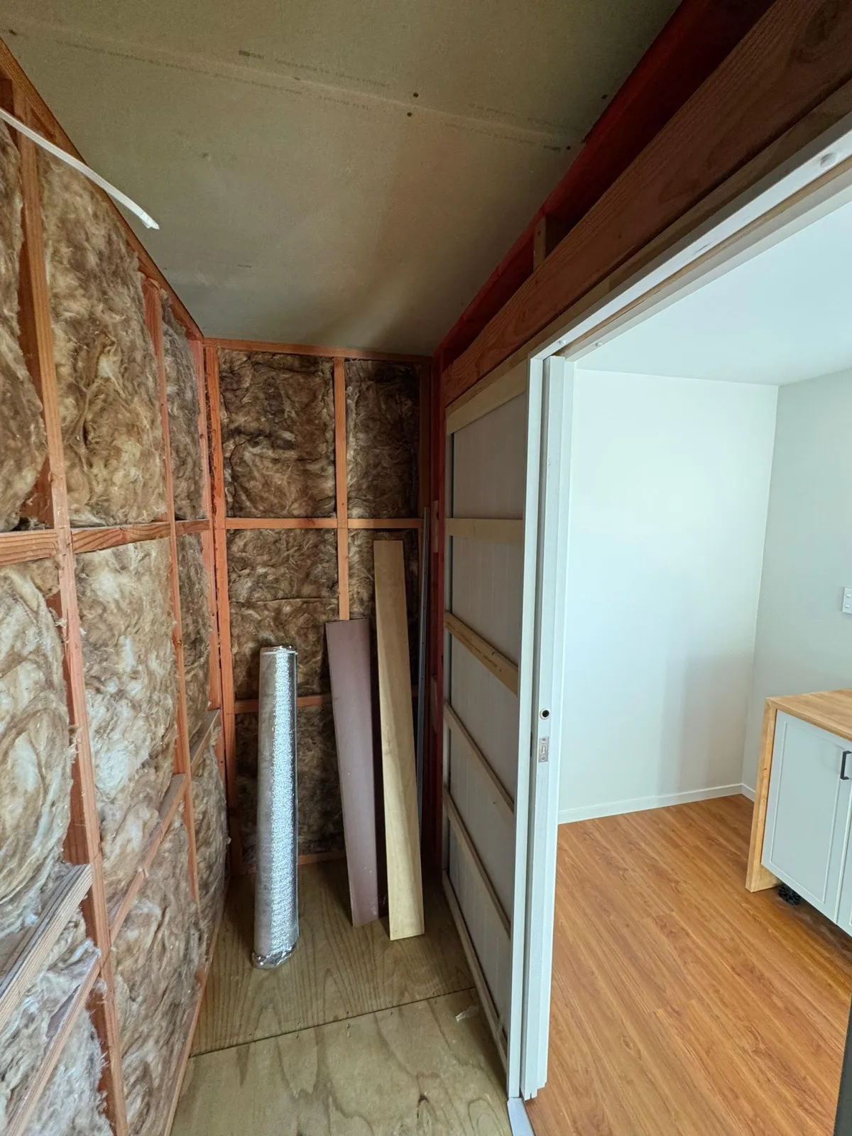 Insulated unfinished room inside cabin, ideal for bathroom or storage conversion.