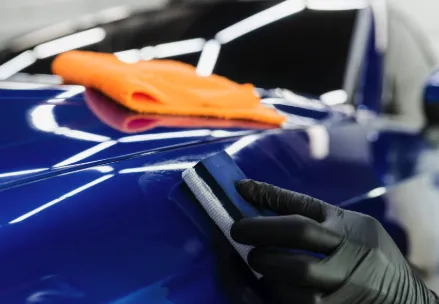 Close-up of ceramic coating being applied to glossy car hood in Raleigh NC.
