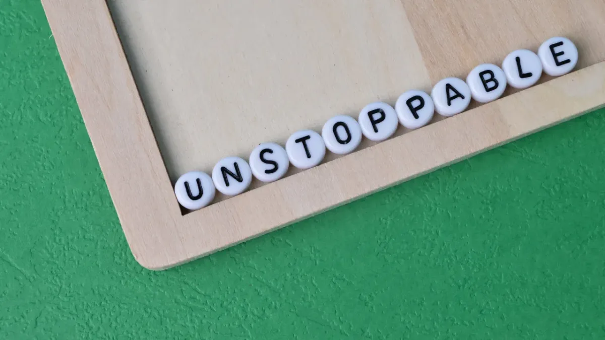 Wooden board on green felt background with unstoppable written in tiles