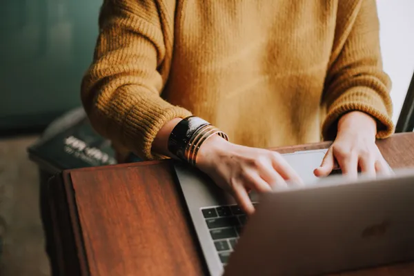 A woman typing over her laptop.
