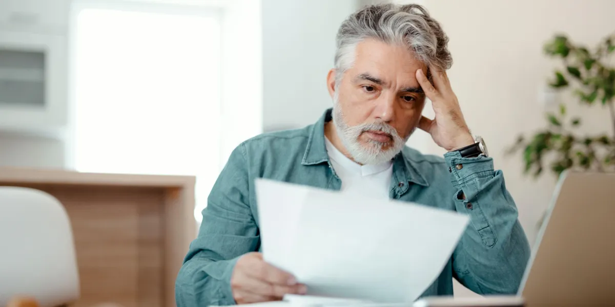 Guy looking worried at sheet of paper
