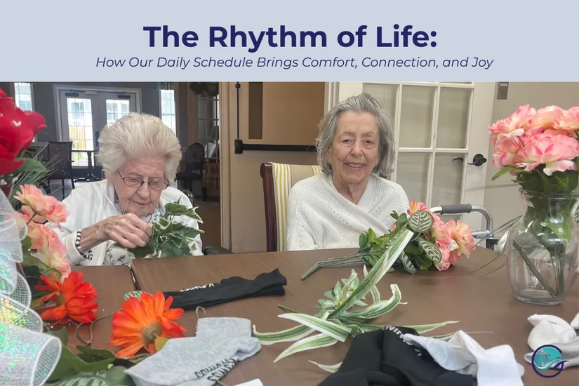 Two residents at Gulf Coast Memory Care participating in a flower arranging activity during Creative Hour, sitting at a table with colorful flowers and craft materials in the bright community dining area