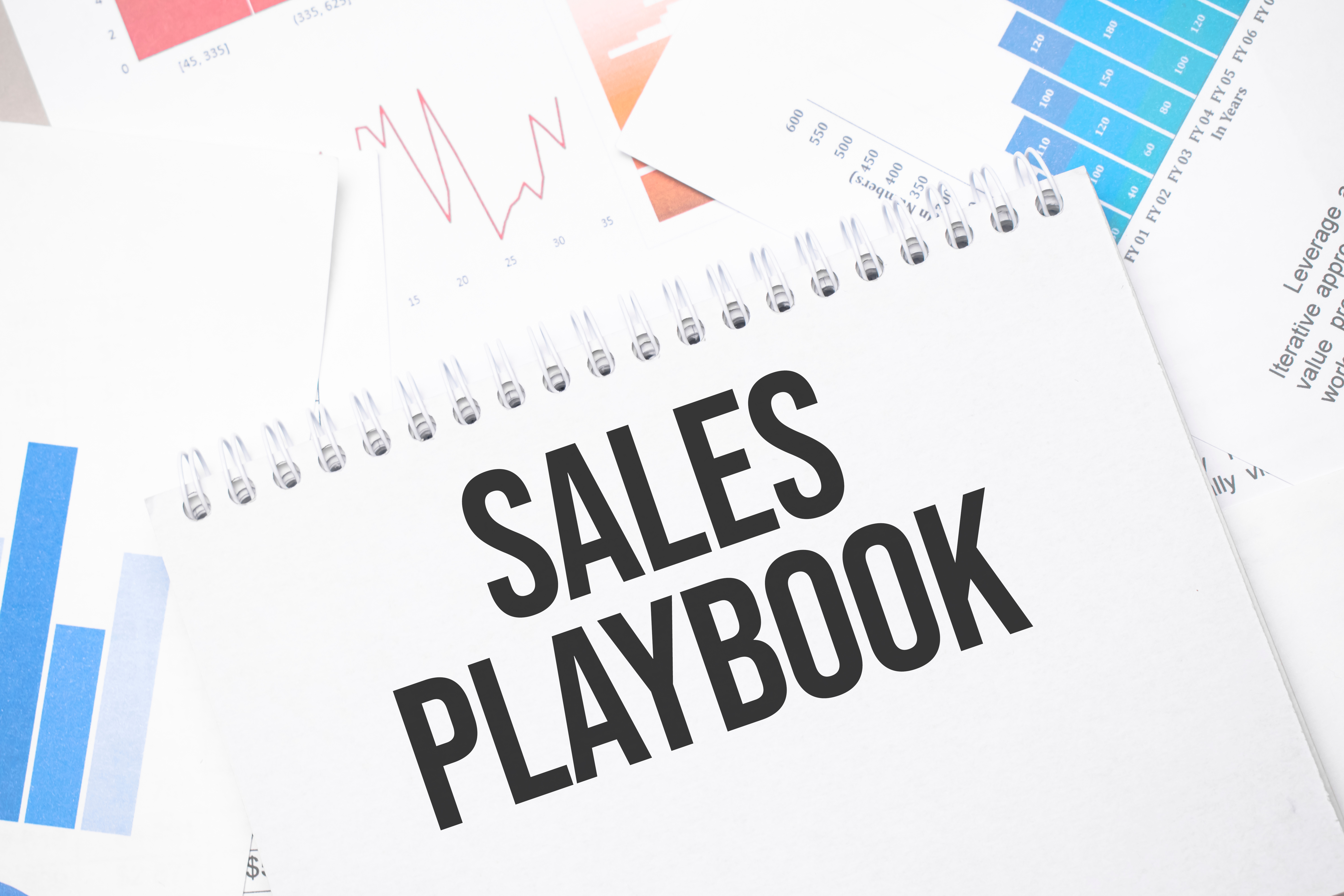 Printed roofing sales playbook with highlighted scripts and sales process steps