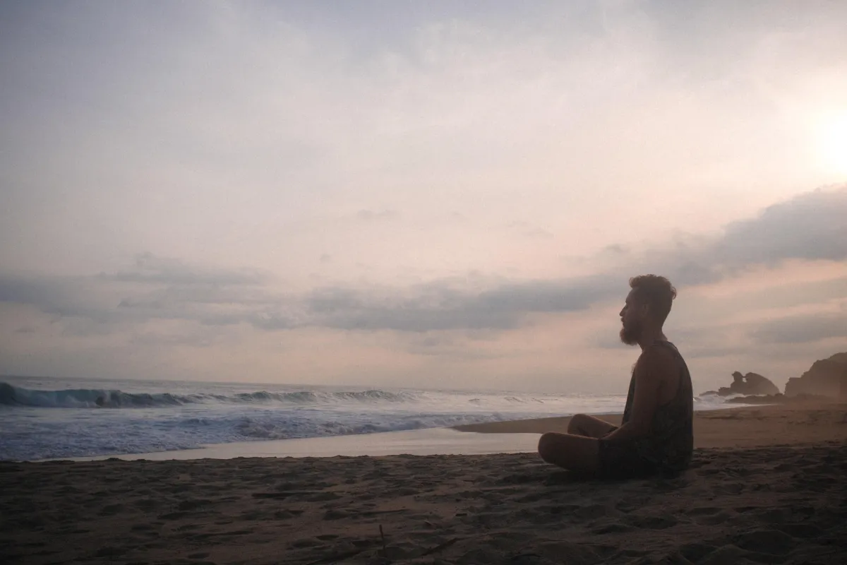 Sitting quietly on a beach looking out towards the ocean