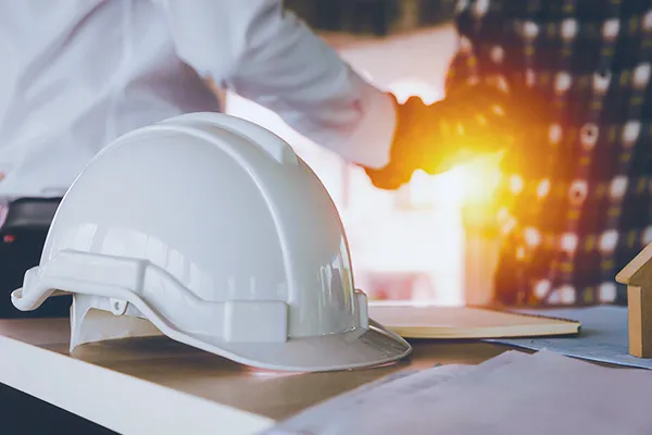 construction hat with two people shaking hands in the background