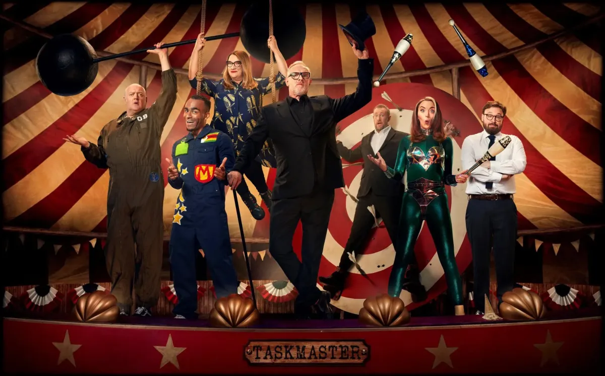 Taskmaster series 14 promo picture with Greg Davies, Alex Horne, Dara O'Brien, Munya Chawawa, Sarah Millican, Fern Brady, and John Kearns in a circus set.