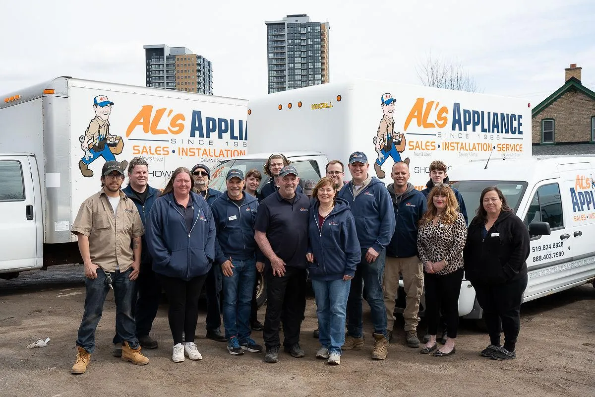 Al's Appliance team in front of their various delivery trucks outside.