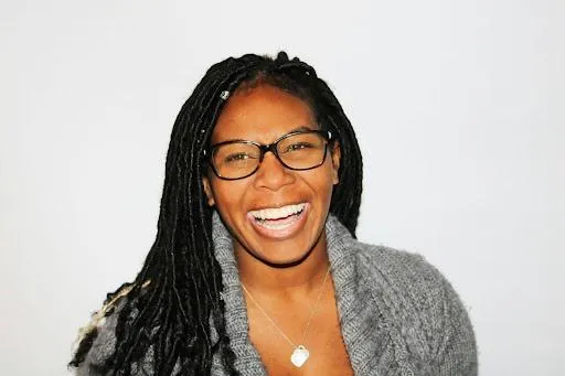 A woman of color smilling for building strong bonds.