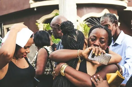 A woman of color hugging her fellow woman displaying empathy.