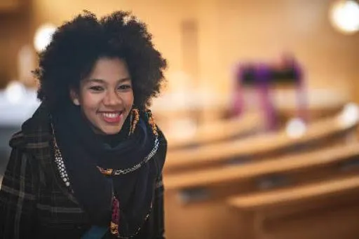 A black woman smiling happily with forgiveness mantras in peace with herself - stock photo