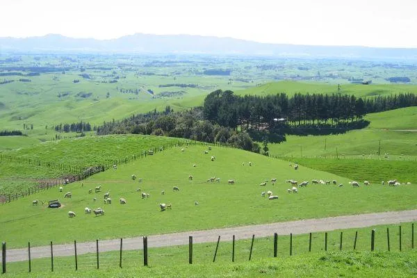 a panoramic view over a farm with a fence in the foreground