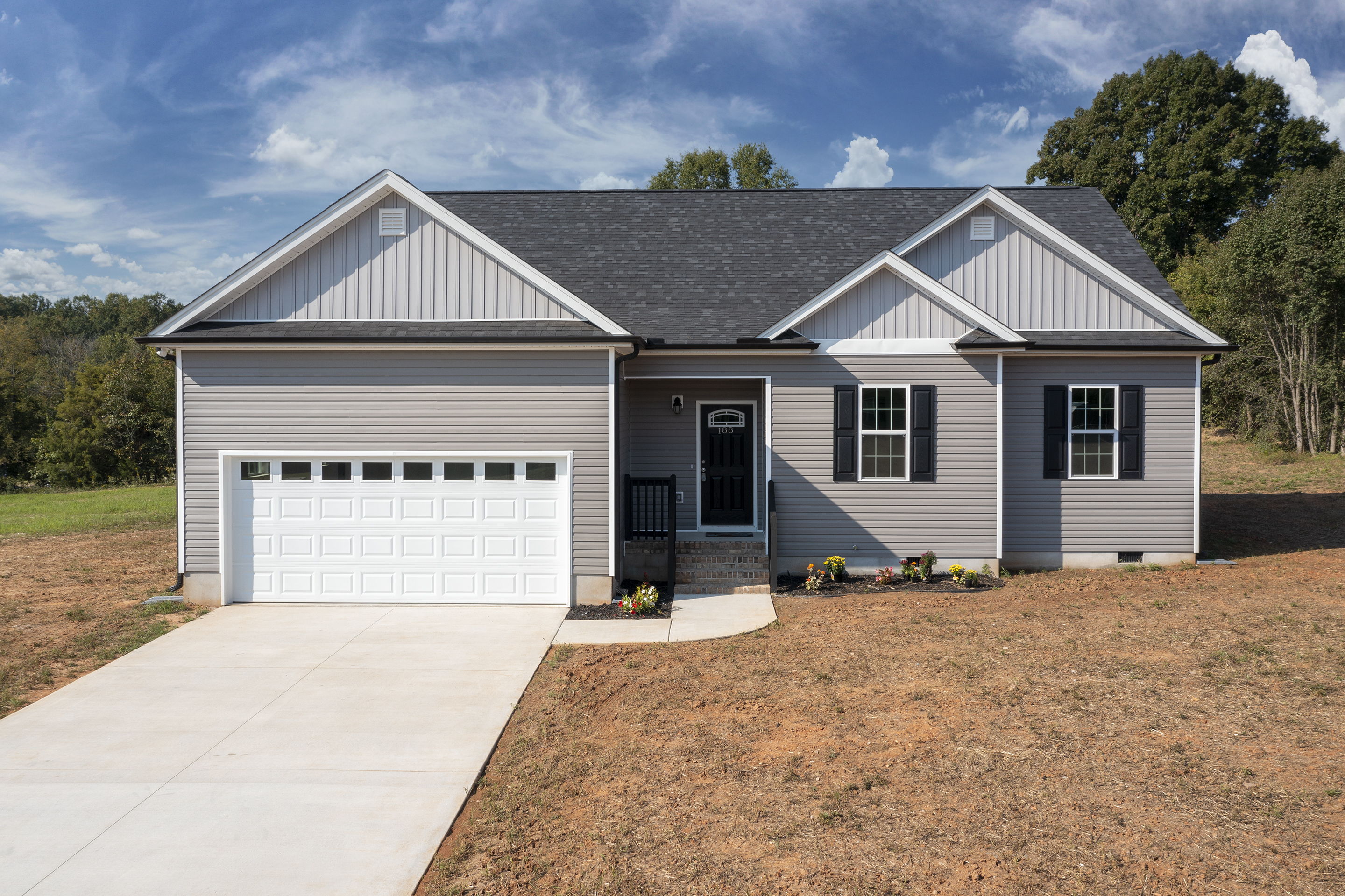 Exterior view of a new 44x38 single-story home with vinyl siding, 3 bedrooms, 2 bathrooms, full basement, and 2-car garage in Linwood, NC (27299).