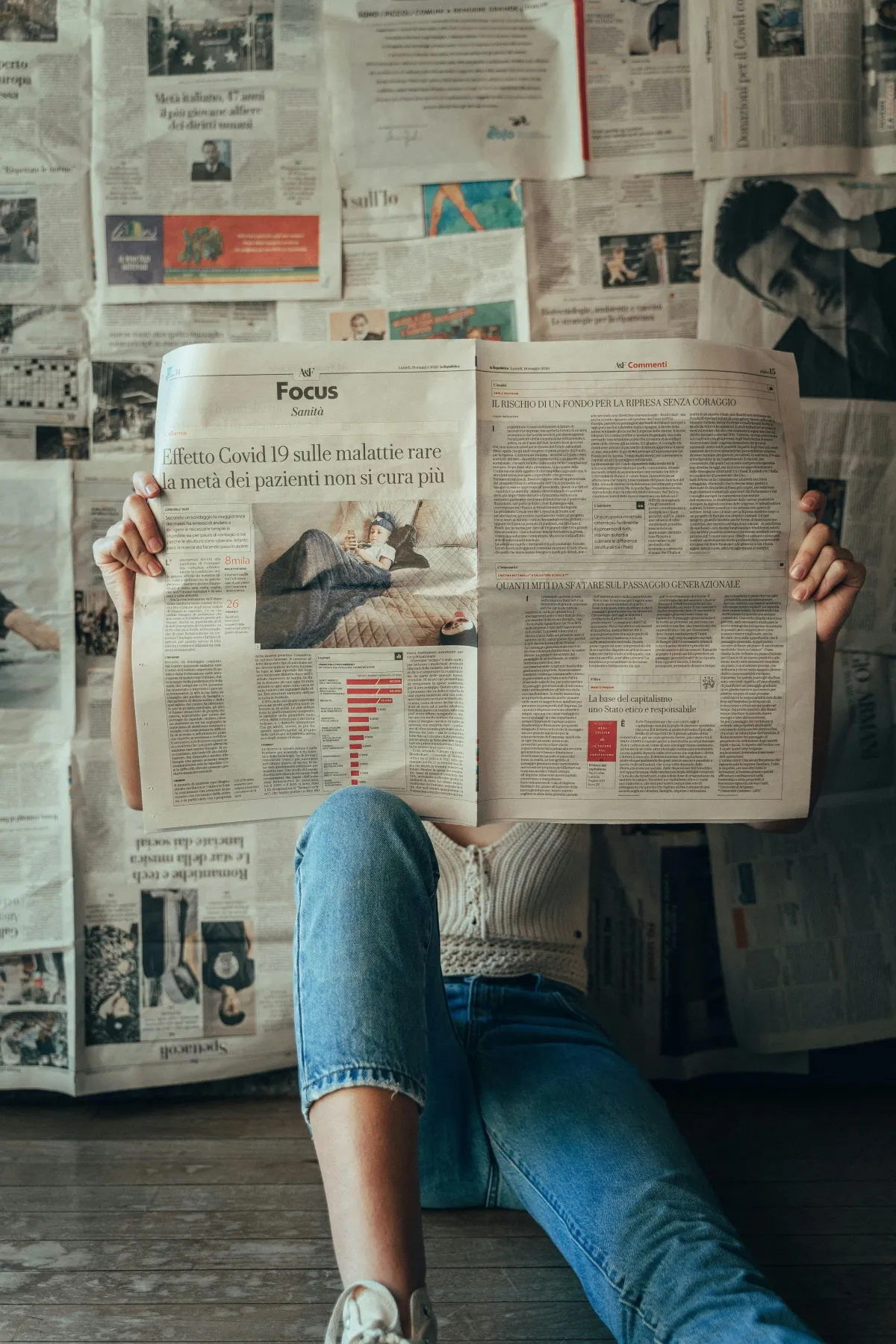 man reading amid many newspapers