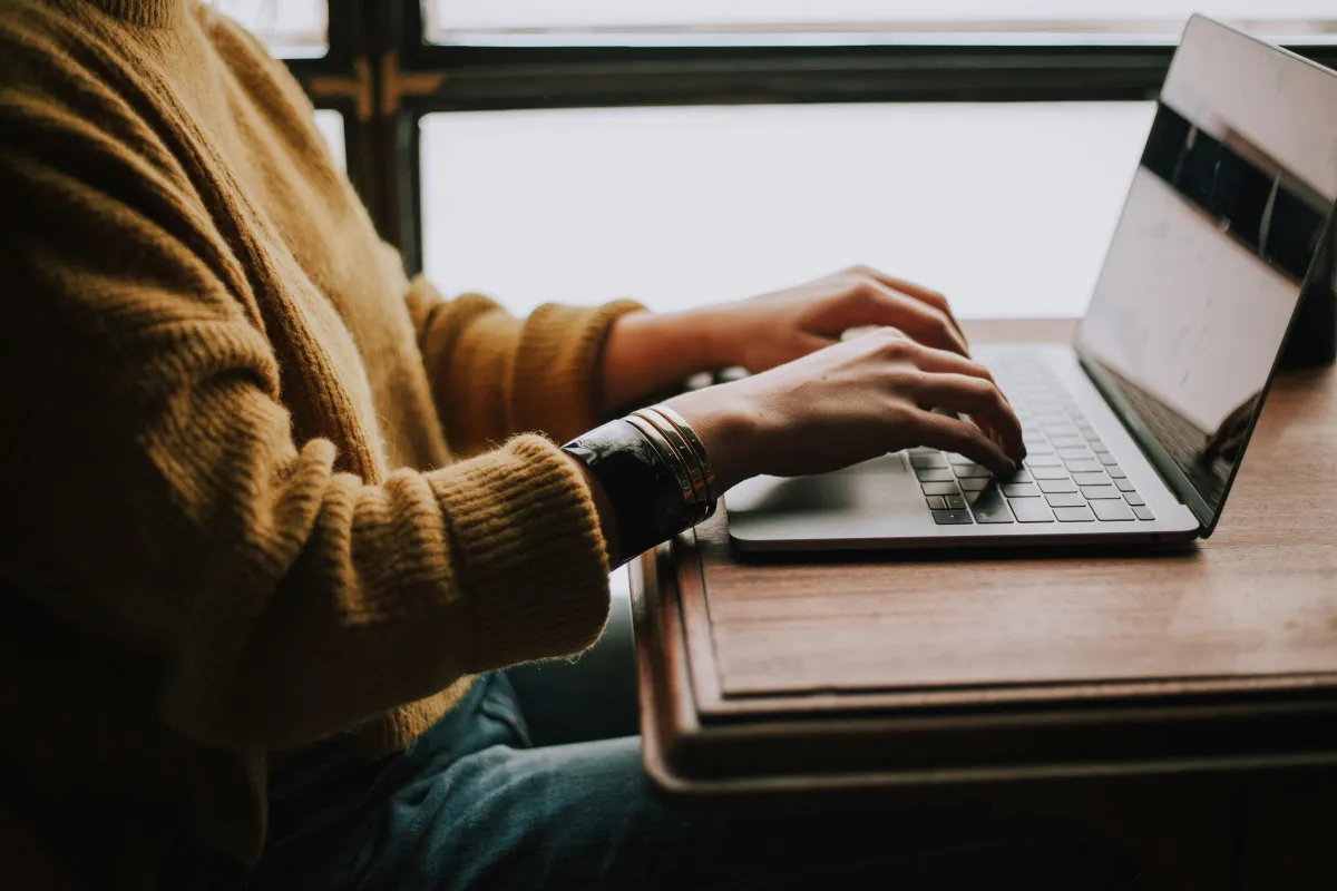 Writer typing out their business book on a laptop computer. 