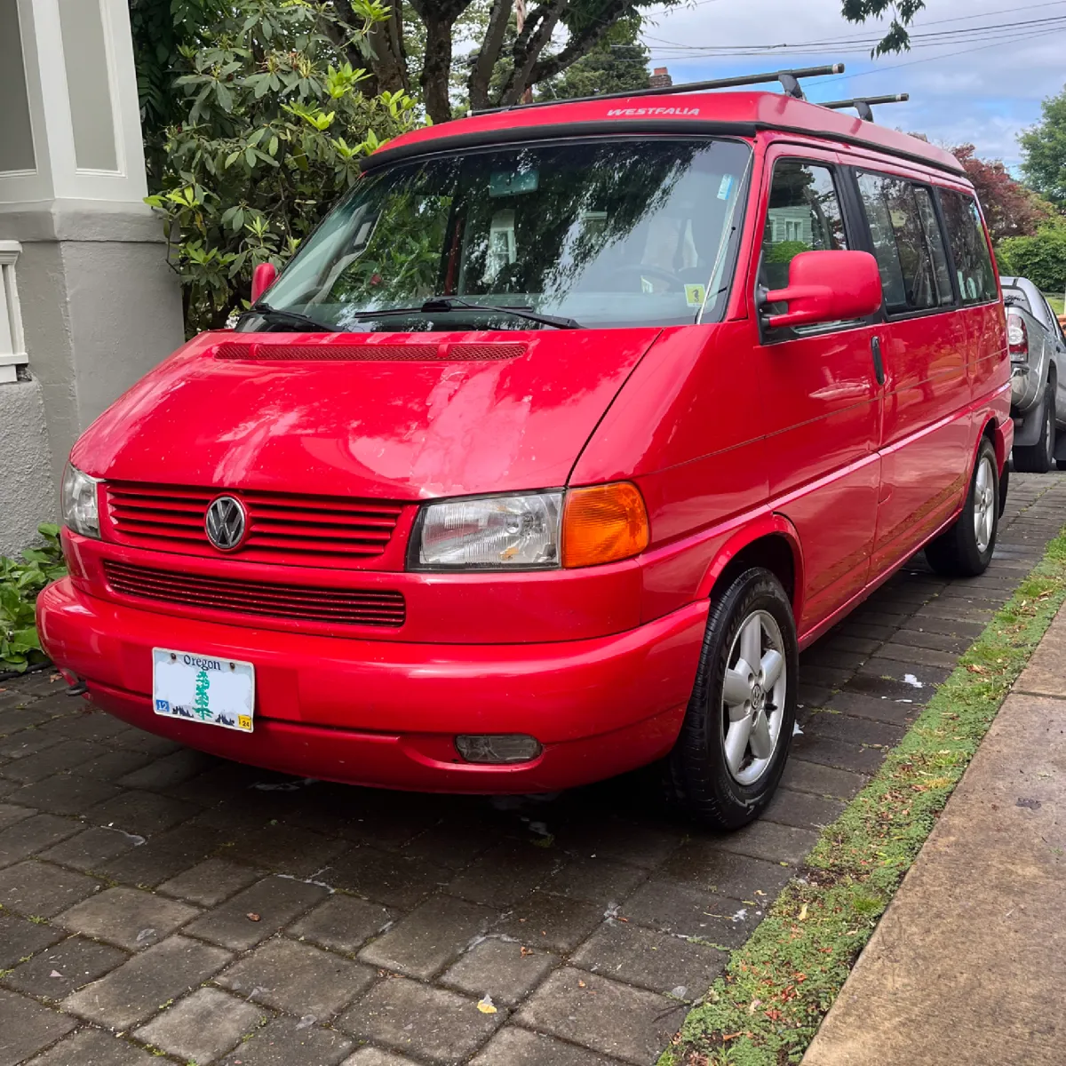 Red minivan detailed and parked curbside in Portland