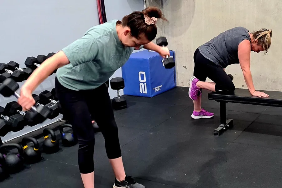 Women lifting weights in a gym – strength training for fat loss.