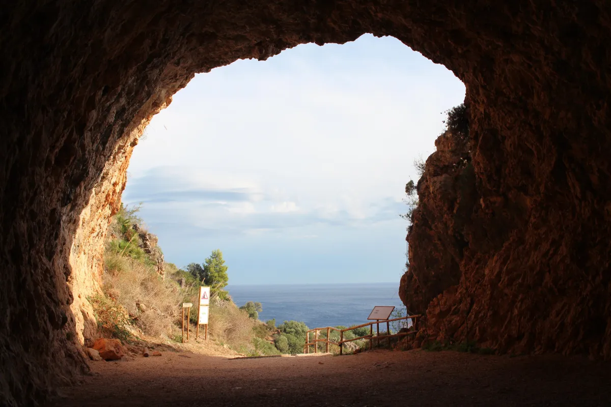 A view of the ocean, looking out of a cave shaped like a find, photographed by Tobias Katlein