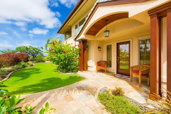 A beautifully maintained home exterior featuring a manicured lawn, and vibrant flower beds.