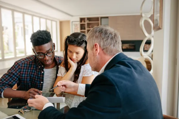 A young military couple guided by a real estate agent through the home buying process.