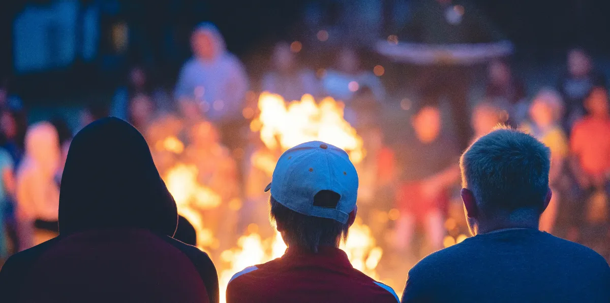 People sitting by a campfire at night