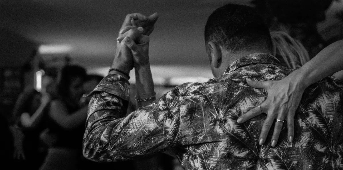 Couple dancing closely in a dimly lit room.