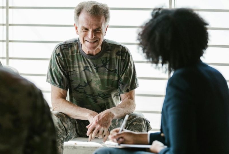 Male veteran speaking with a female in business attire during an informal conversation.