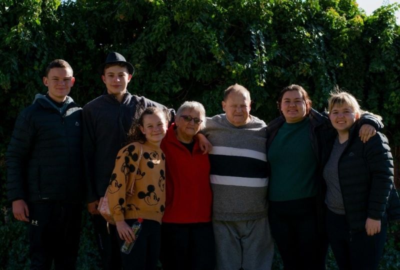 Family huddled together for a photograph, representing support, protection, and peace of mind.