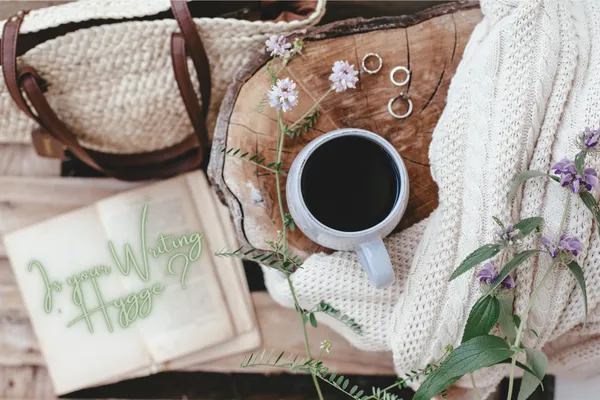romantic image of coffee, an open book and a summer bag