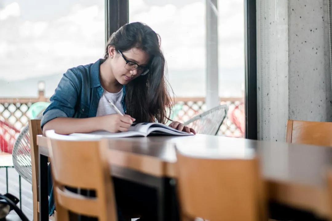 Imagem de estudante estudando inglês com anotações de phrasal verbs —